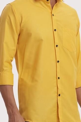 Yellow shirt with black buttons on a plain background
