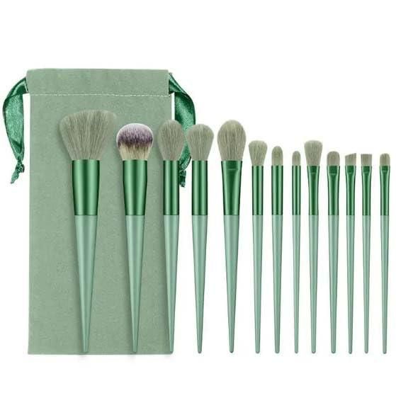 Set of green makeup brushes with a matching pouch on a white background