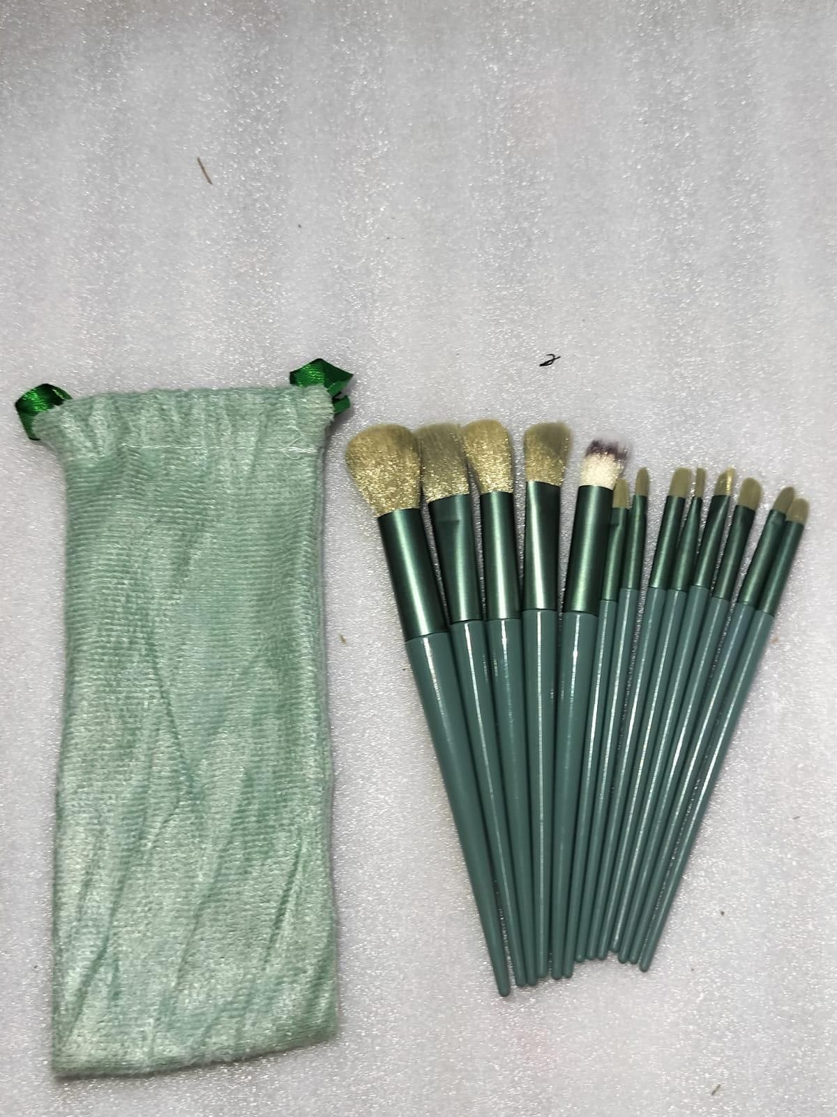 Set of makeup brushes with a green pouch on a gray background