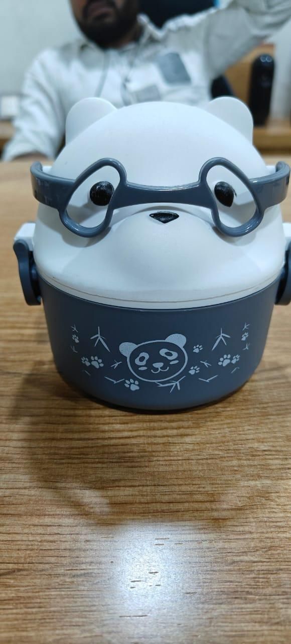 Cute panda-shaped container with glasses on a wooden surface