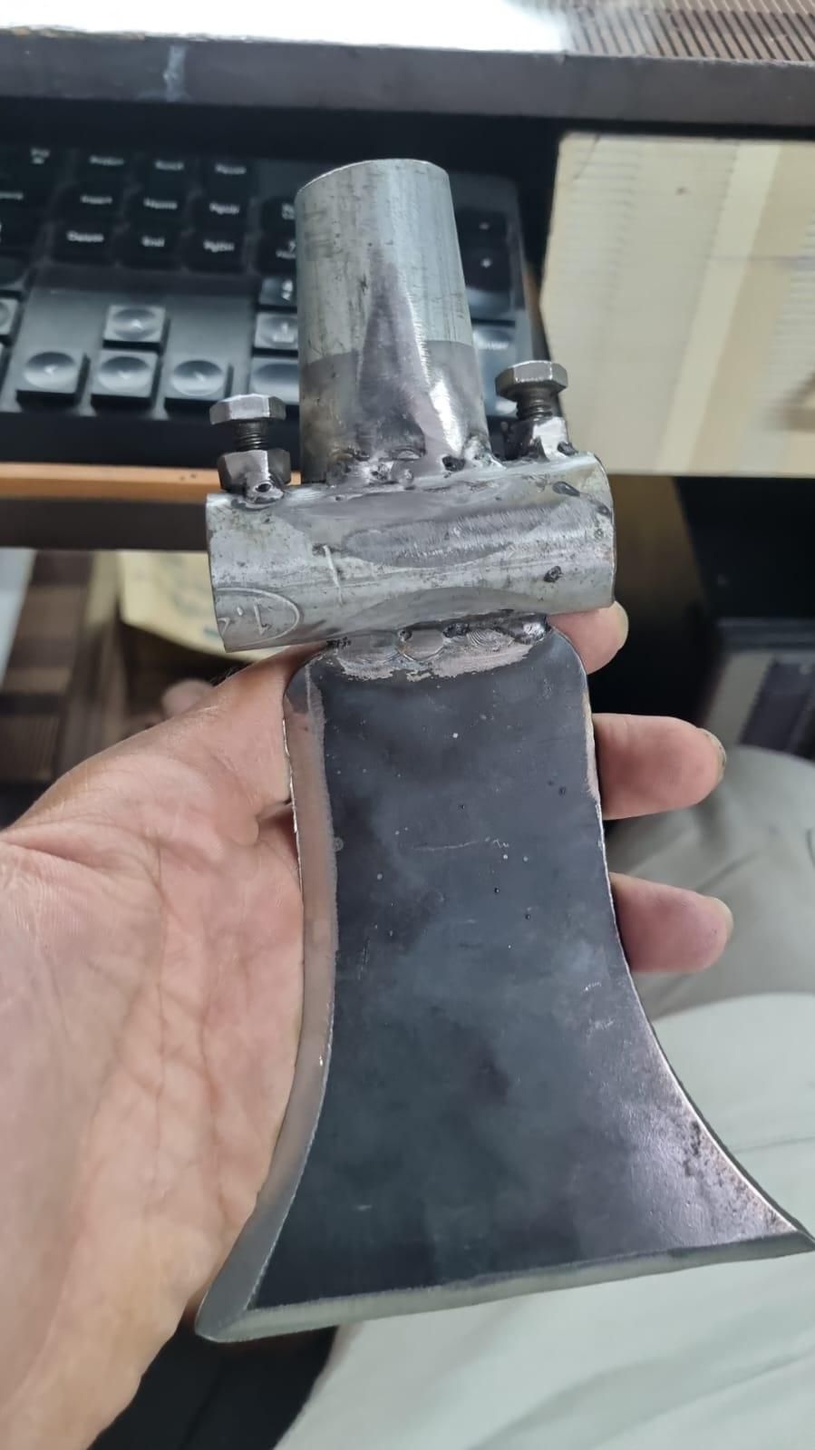 Metal axe held by a hand with a blurred background
