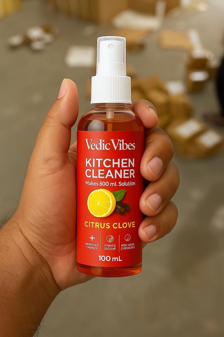 Hand holding a bottle of Vedic Vibes Kitchen Cleaner with a blurred background