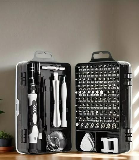 Tool kit with various tools and bits on a wooden surface.