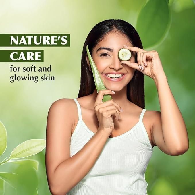 Woman holding a cucumber slice to her eye with a green background and 'Nature's Care' text.