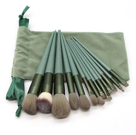 Set of green makeup brushes with a matching pouch on a white background