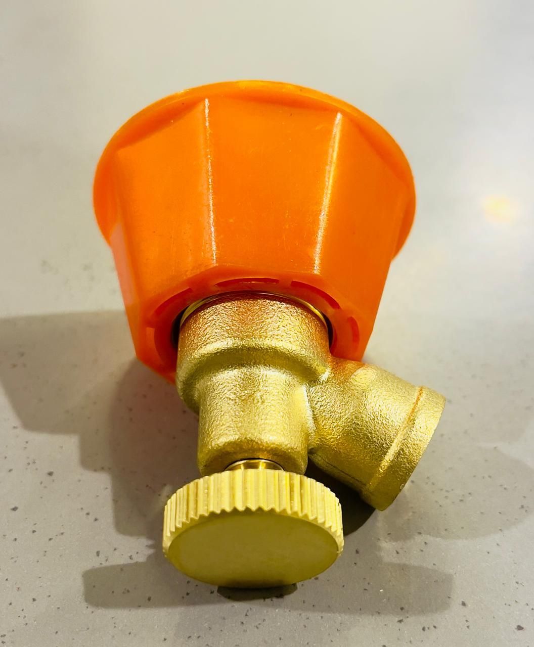 Gold and orange valve on a light gray background