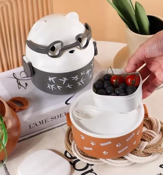 Stackable containers with a hand reaching for one, placed on a surface with a plant and book in the background.
