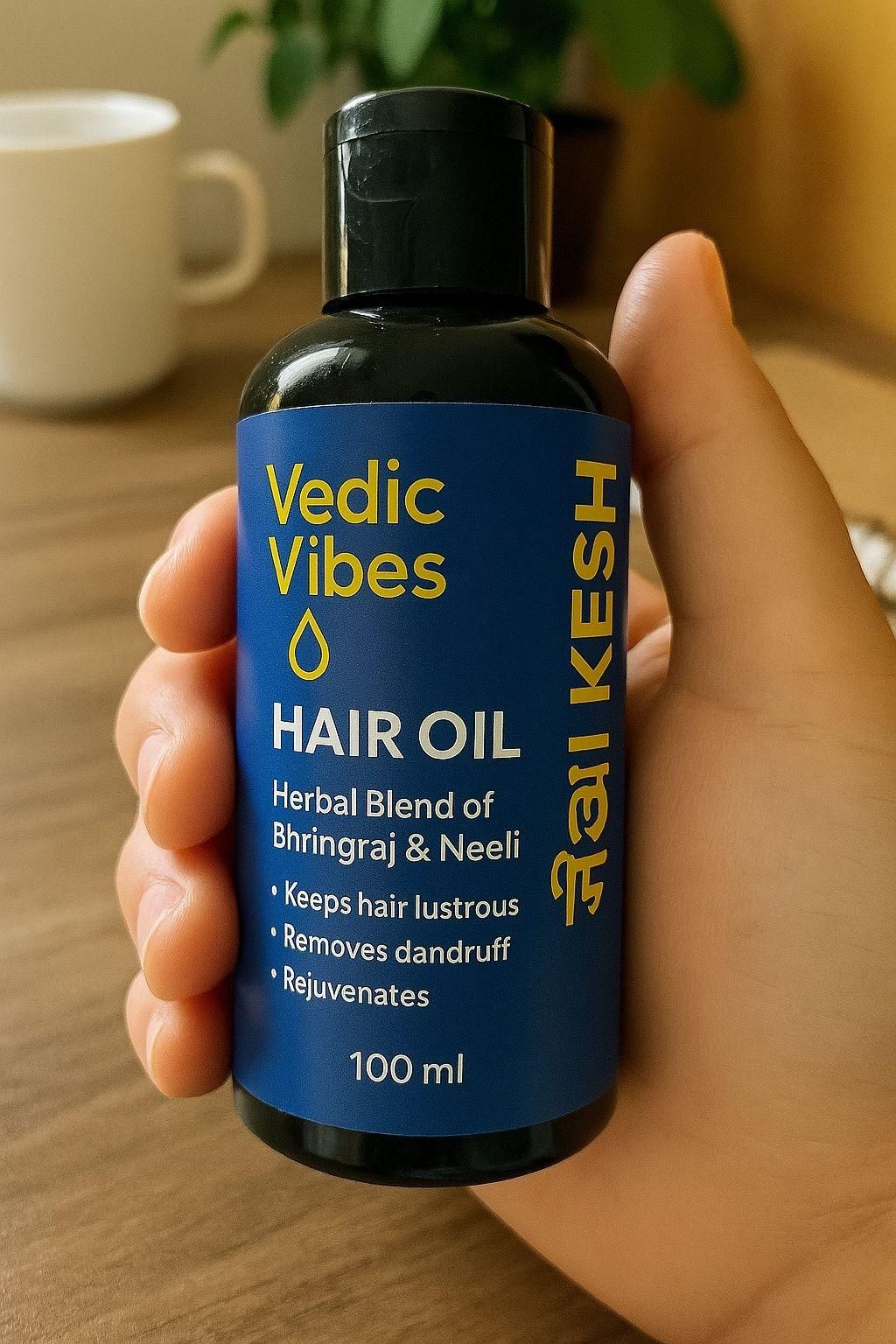 Hand holding a bottle of Vedic Vibes Satkesh hair oil on a wooden surface with a blurred background.