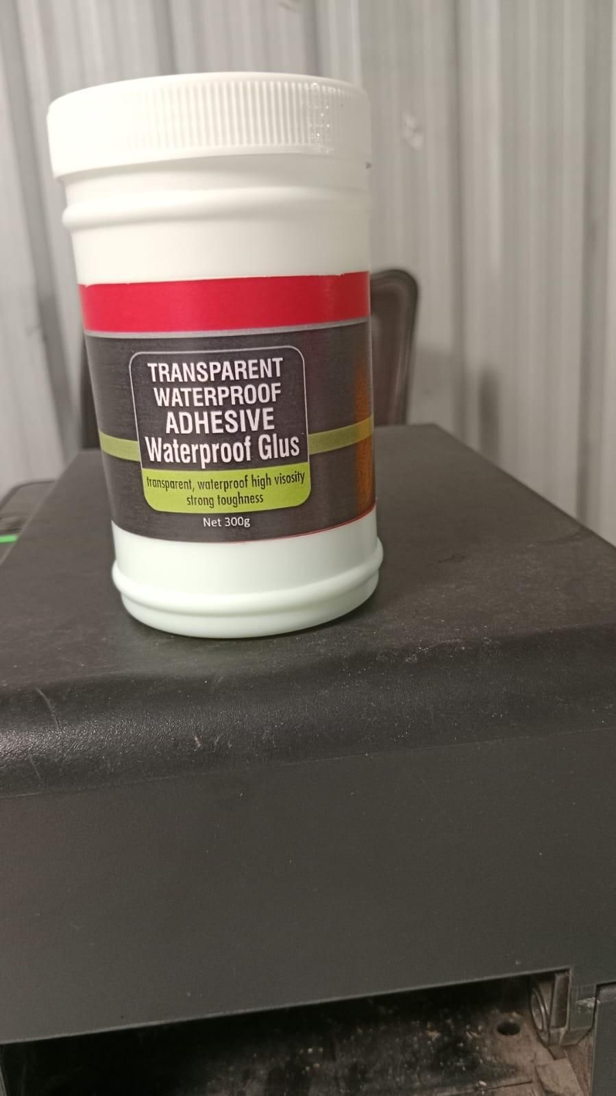 Container of transparent waterproof adhesive on a dark surface
